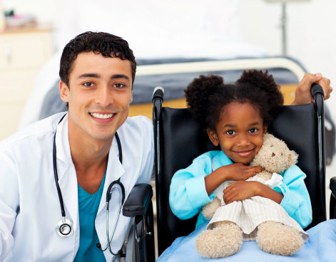 doctor and kid in wheelchair smiling